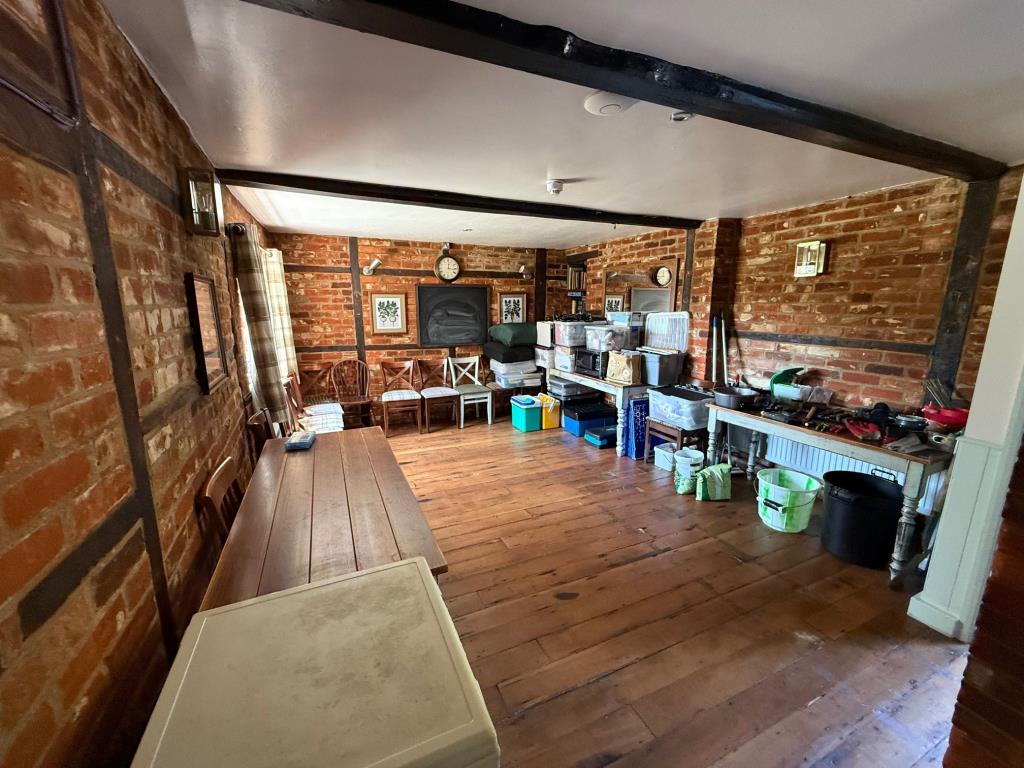 Lot: 102 - PUBLIC HOUSE - Storage area with exposed brick walls and wooden floor